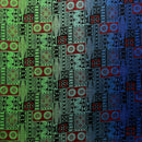 A flat-lay view of a Fijian Tapa Barkcloth fabric featuring a traditional geometric pattern. The design consists of repeating rectangular tiles in shades of green, red, and blue, filled with intricate black tribal motifs including sunbursts, triangles, and linear hatches.