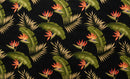 Close-up of a tropical fabric pattern featuring orange and yellow Bird of Paradise flowers and pink Plumeria blossoms interspersed with various green palm leaves on a solid black background.